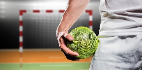 Sportsman holding a ball against digital image of handball goal  - obrazy, fototapety, plakaty