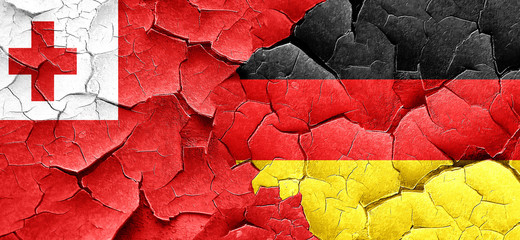 Tonga flag with Germany flag on a grunge cracked wall