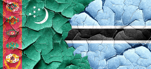 Turkmenistan flag with Botswana flag on a grunge cracked wall