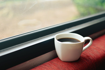 Cup of black coffee  against the window in the morning  , vintag