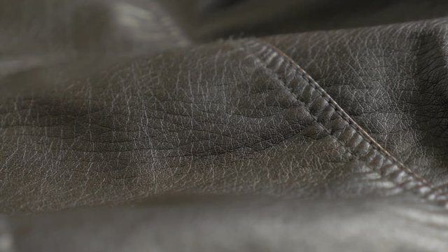 Leather jacket texture close-up slow pan 4K 2160p 30fps UltraHD footage - Dark brown shiny leather texture 4K 3840X2160 UHD panning video