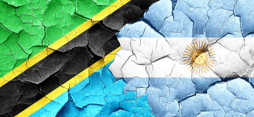 Tanzanian flag with Argentine flag on a grunge cracked wall