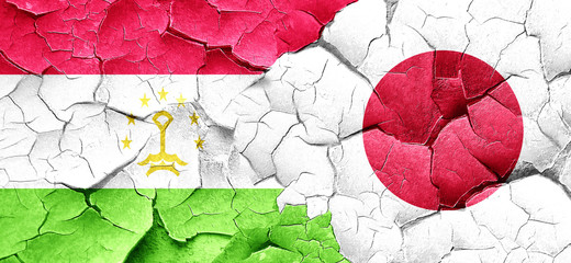 Tajikistan flag with Japan flag on a grunge cracked wall