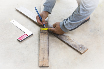 Male carpenter working with wood pencil and tape measure at work place.Background craftsman tool.Zoom in.