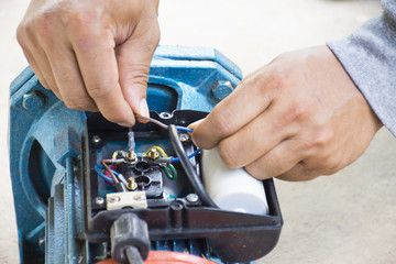 Electric motor and man working equipment repair on cement floor background.Backgroud motor or...
