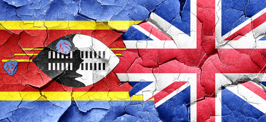 Swaziland flag with Great Britain flag on a grunge cracked wall