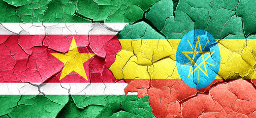 Suriname flag with Ethiopia flag on a grunge cracked wall