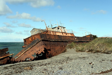 Rusty ship on the shore of the Strait of Magellan in the village of San Gregorio.