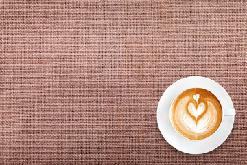 Top view latte art coffee on cotton fabric background