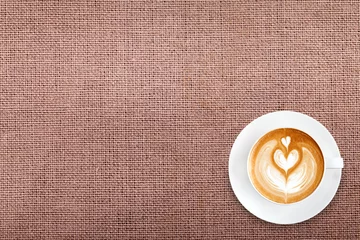 Rolgordijnen Top view latte art coffee on cotton fabric background © sripfoto
