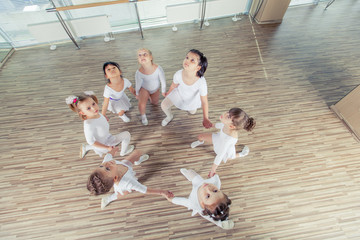 group of seven little ballerinas sitting on the floor. They are good friend and amazing dance performers