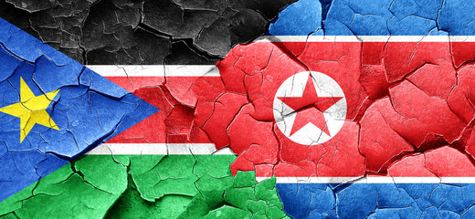 south sudan flag with North Korea flag on a grunge cracked wall