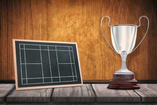 Focus on a trophy against black board on a wooden table