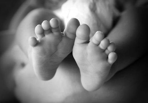 Photo of newborn baby feet in soft focus - black and white