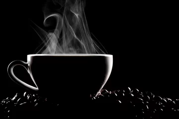 Foto auf Acrylglas Cafe Dampfende Kaffeetasse und Kaffeebohnen im Studiospiel von Licht und Schatten auf schwarzem Hintergrund.