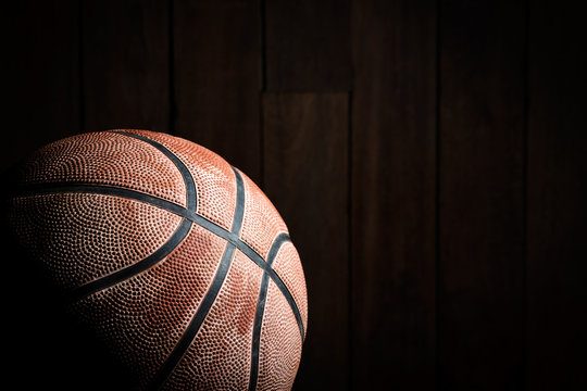 Basketball on wood background with copy-space and dark tone.