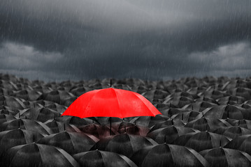 red umbrella in mass of black umbrellas - obrazy, fototapety, plakaty