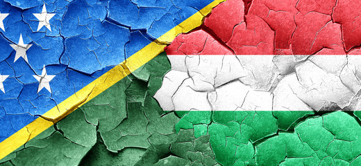 Solomon islands flag with Hungary flag on a grunge cracked wall
