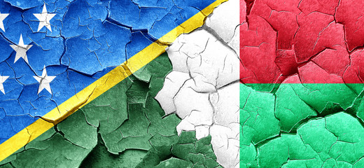 Solomon islands flag with Madagascar flag on a grunge cracked wa