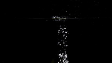 Super slow motion shot: green apple falls and floats in water, black background - Powered by Adobe