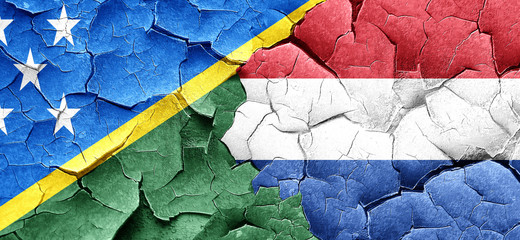 Solomon islands flag with Netherlands flag on a grunge cracked w