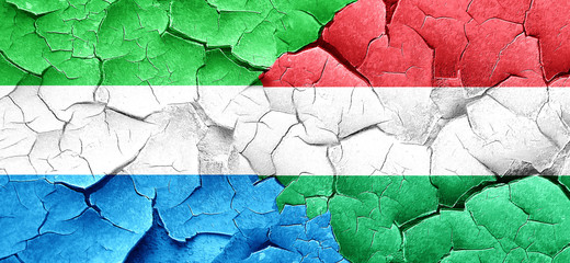 Sierra Leone flag with Hungary flag on a grunge cracked wall