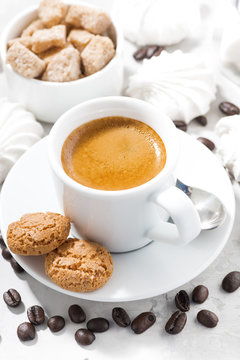 cup of espresso and sweet cookies on a white table, vertical