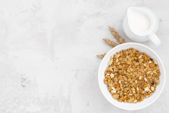 homemade baked muesli and milk on white background, top view