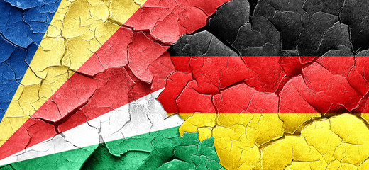 seychelles flag with Germany flag on a grunge cracked wall