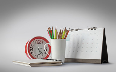Cups, pencils, calendars, desk clock shot in the studio.