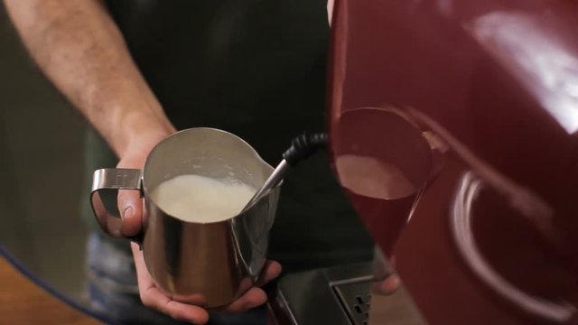 Barista starts steaming milk for coffee. Close up