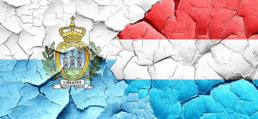 san marino flag with Luxembourg flag on a grunge cracked wall