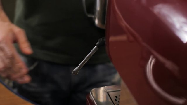 Barista finishes steaming milk for coffee and cleans the steam arm up. Close up
