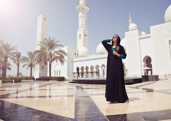 Beautiful woman in abaya dreaming at the grand mosque