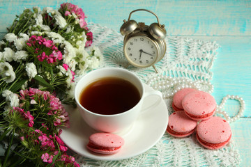 macaroons and chrysanthemum on white wooden background with Cup of tea