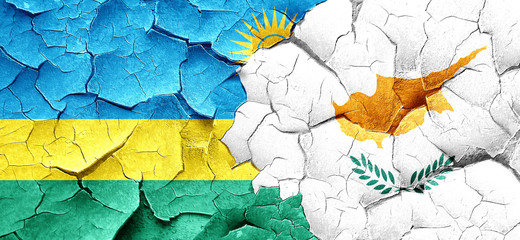 Rwanda flag with Cyprus flag on a grunge cracked wall