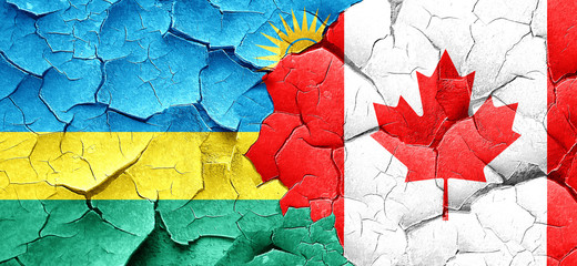 Rwanda flag with Canada flag on a grunge cracked wall