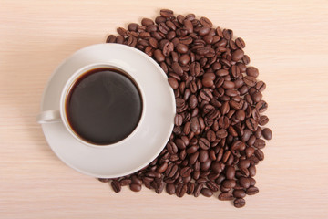 Coffee beans and a white cup on table