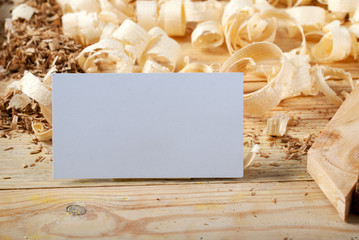 Business card on wooden table for carpenter tools with sawdust.