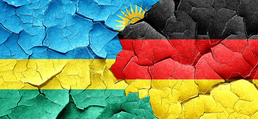 Rwanda flag with Germany flag on a grunge cracked wall