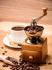 Antique Coffee Grinders with coffee beans and coffee cup in stud