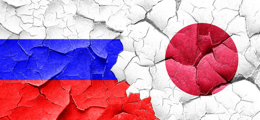 Russia flag with Japan flag on a grunge cracked wall