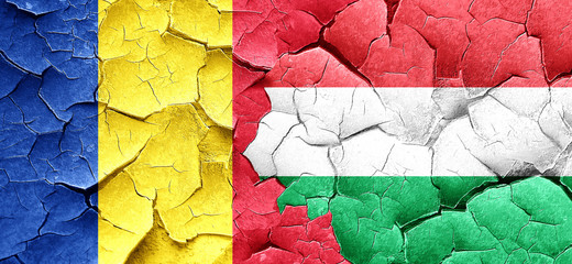 Romania flag with Hungary flag on a grunge cracked wall