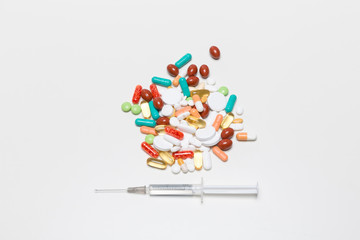 Tabletten und eine Spritze mit Kanüle