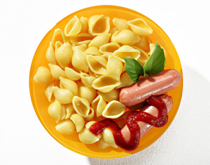 Expertly cooked macaroni shells with sausages in orange plate on white background. Close up, top view, high resolution product.