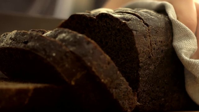 Cutting Slices of Brown Bread on Wooden Boards, slow motion. Close-Up of Dark Bread. knife cut