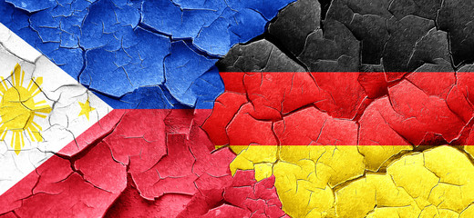 Philippines flag with Germany flag on a grunge cracked wall