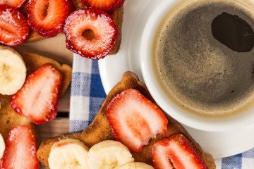coffee and toast with strawberries and bananas