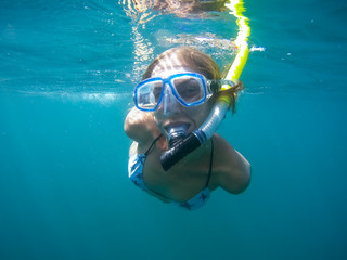 Naklejka premium Underwater shot of the woman moving on the breath hold in the depth. Amed village, Bali, Indonesia