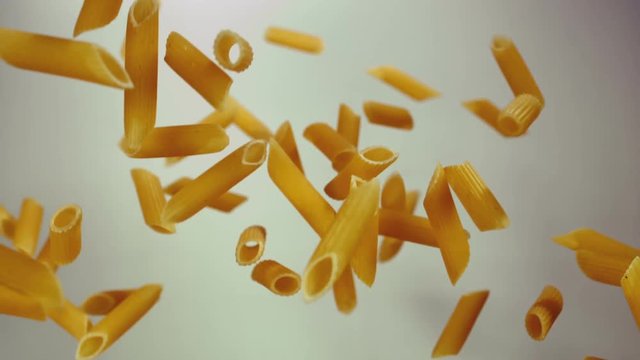 pasta penne falling on a white background